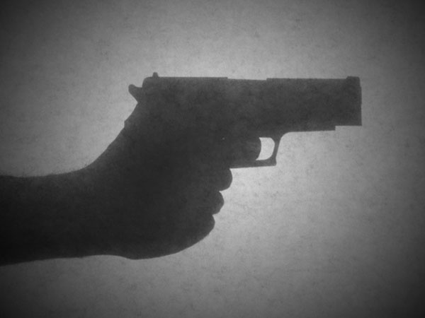 A shadow of a hand on a gun.