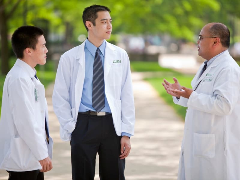 Three doctors at Rush University Medical Center chatting outside.